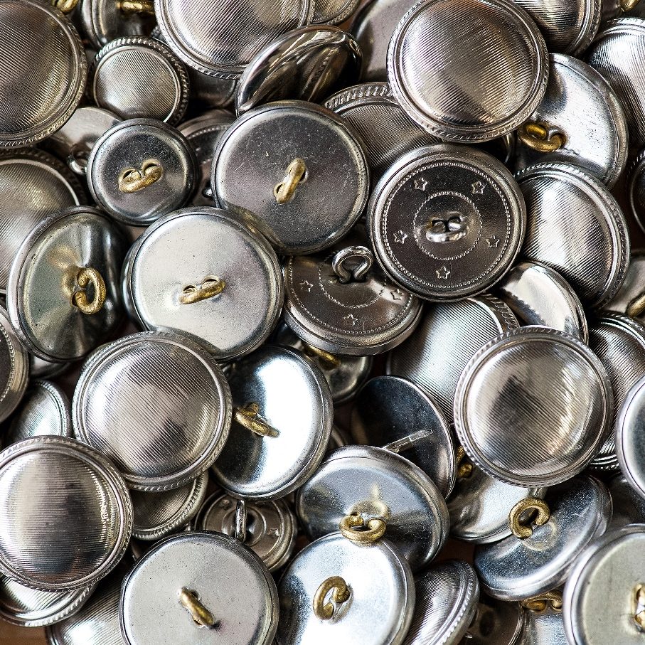 stock-photo-background-texture-of-a-pile-of-matched-round-silver-metal-buttons-for-making-garments-in-a-full-278915924